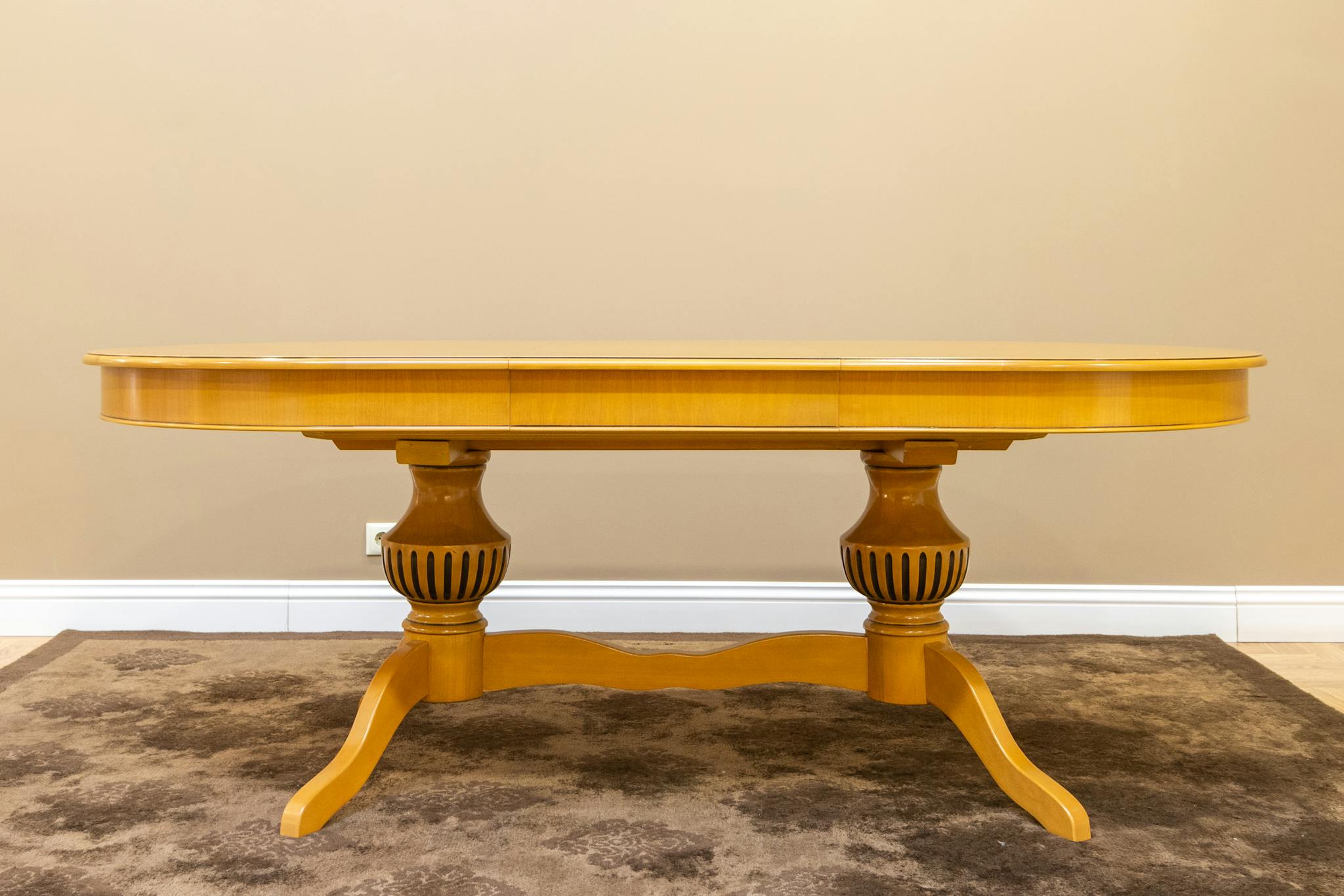 A sophisticated wooden table displayed in a minimalist room with ample copy space and neutral tones.